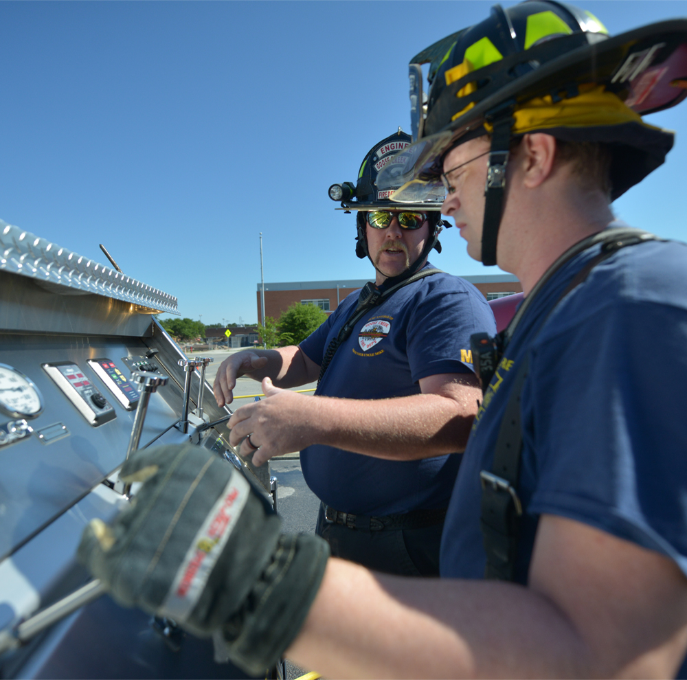 Two Goose Creek firefighters use firefighting equipment