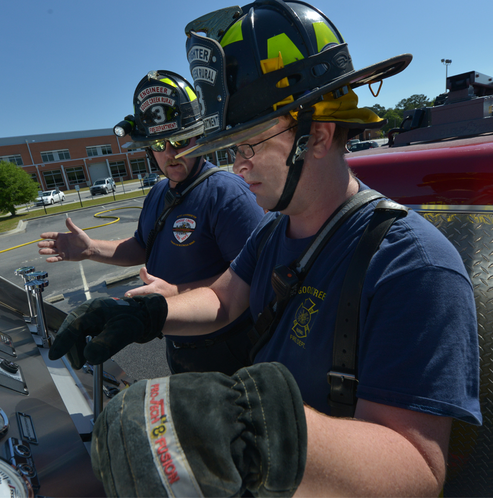 Two Goose Creek firefighters use firefighting equipment